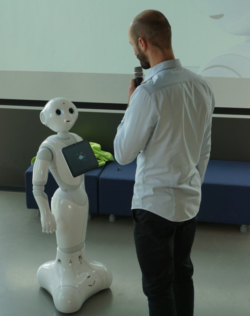 Schüler steht vor dem Roboter Pepper in der Zukunftswerkstatt